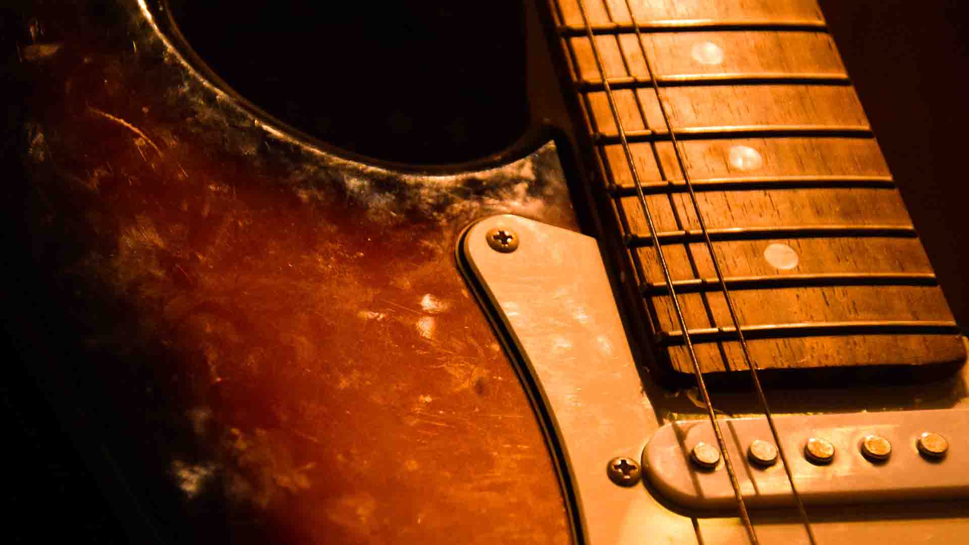 hero image of a guitar in a dark background